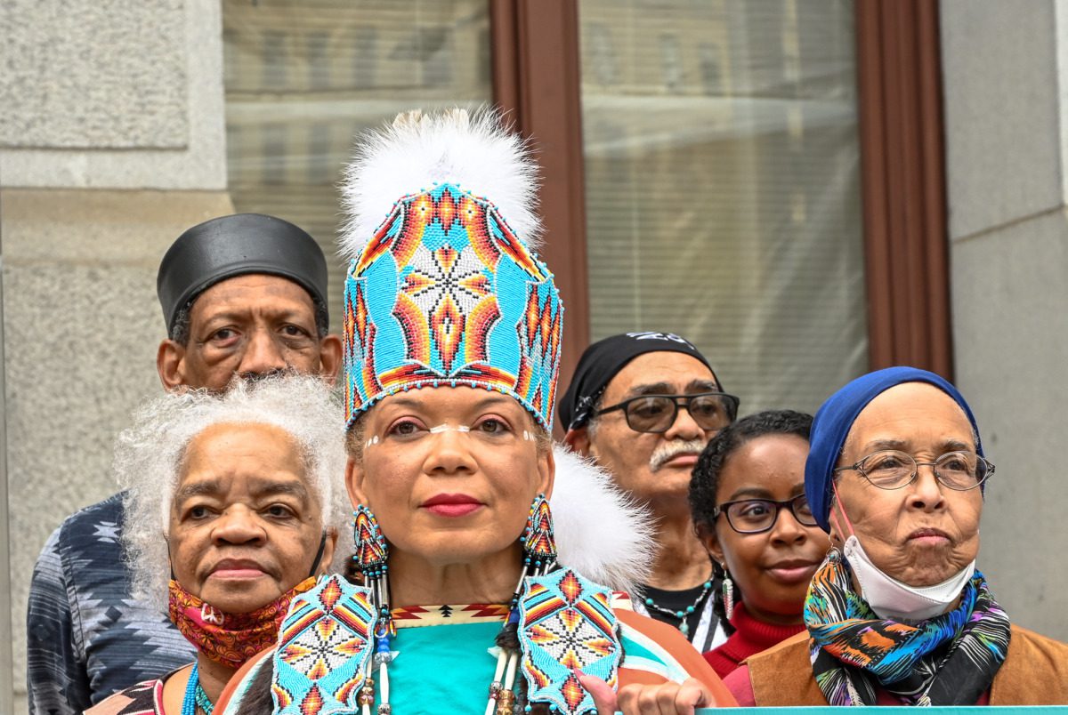 Indigenous people standing outside a building.