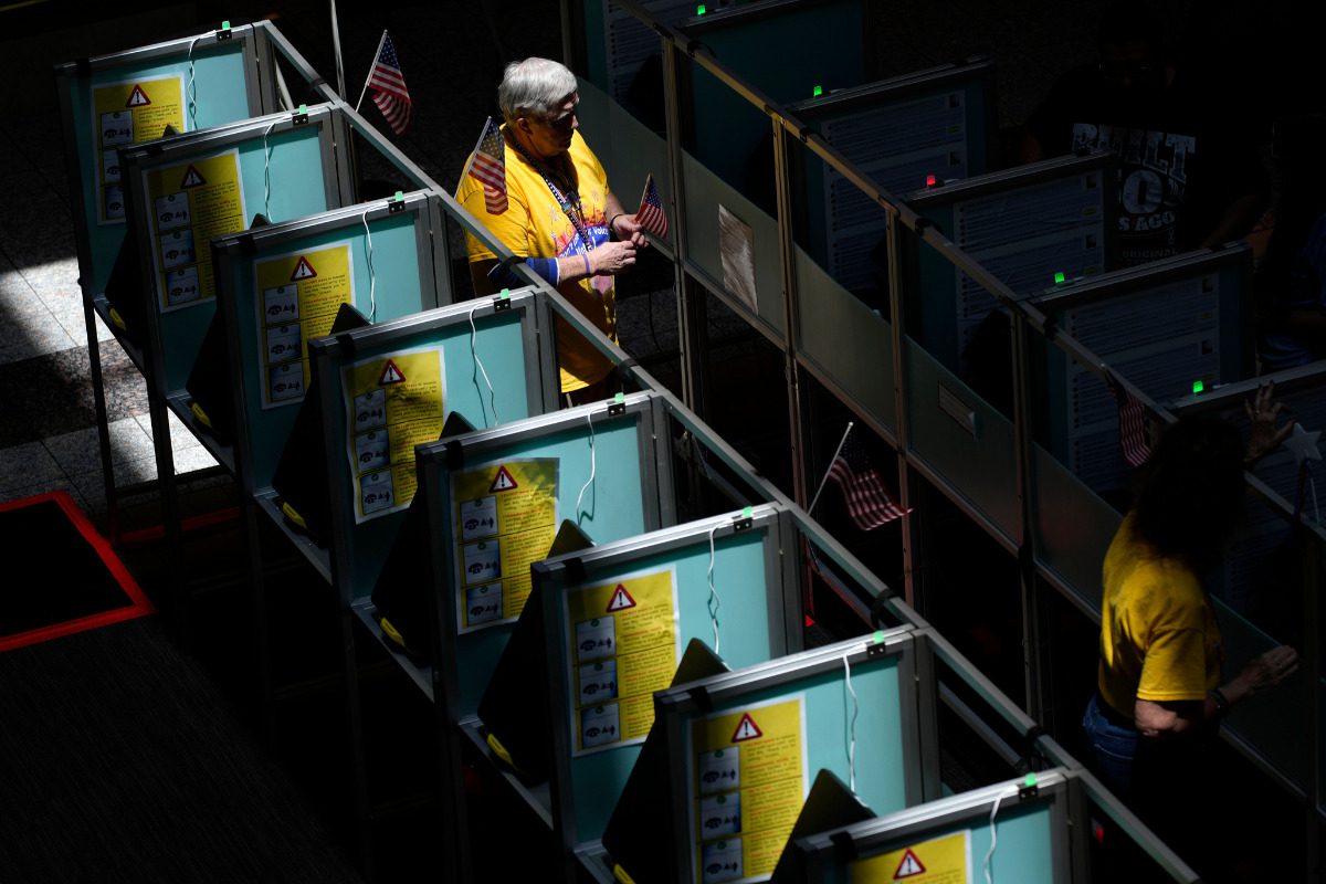 Poll workers help people vote in the Nevada primary at a polling place, Tuesday, June 11, 2024, in Henderson, Nev.