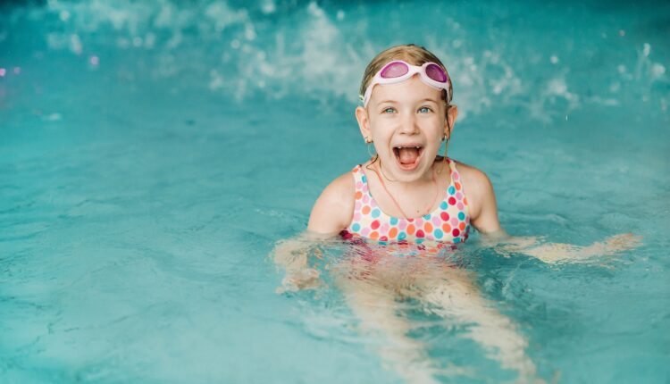 Kids play in aqua park. Children at water playground of tropical amusement park. Little girl at swimming pool. Child playing at water. Swim wear for young kid